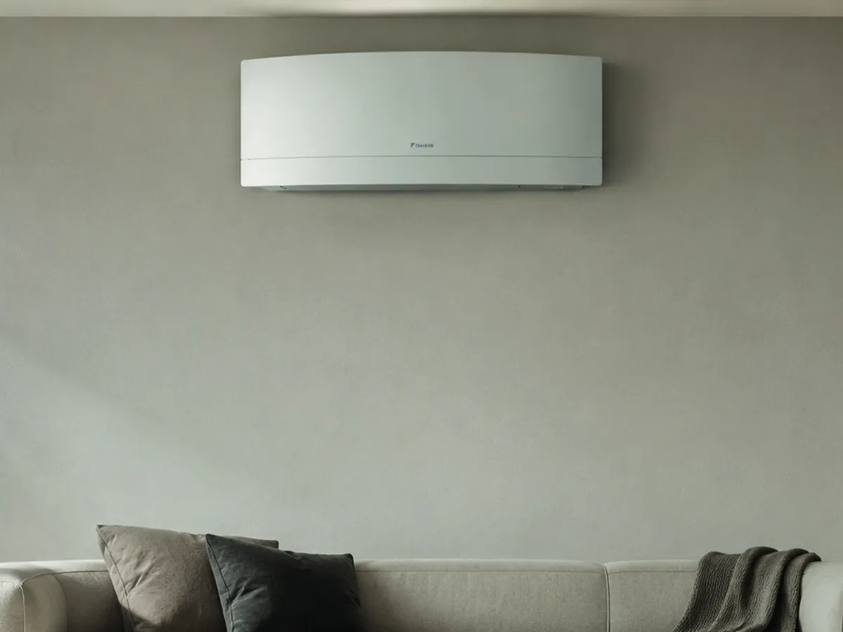 Witte Daikin airco aan de muur boven de bank in een woonkamer